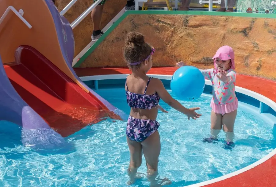 enfants dans une piscine devant un toboggan